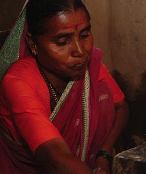 A woman lighting a smoke-less fire to cook food in rural India